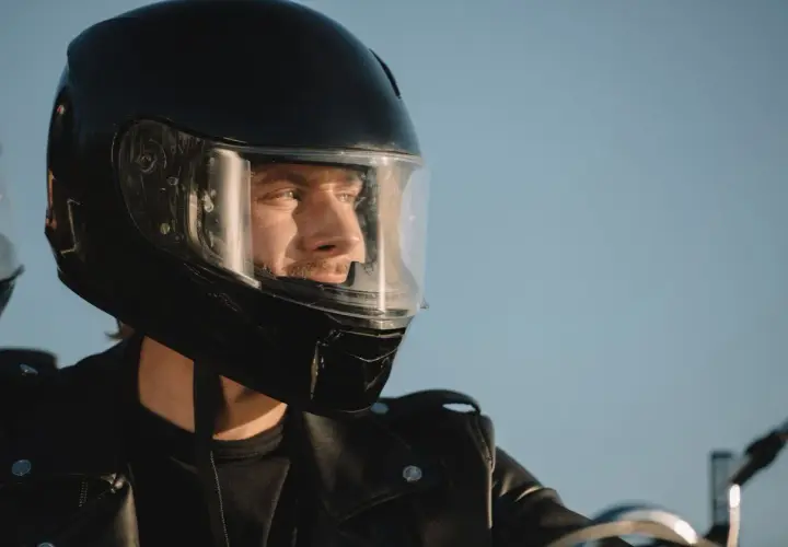 Hombre con casco de moto negro, listo para la aventura. Su mirada refleja la libertad y la seguridad que ofrece la homologación DOT.