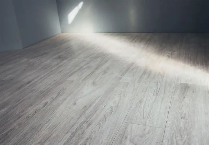 Pavimento in gres porcellanato effetto legno grigio, con luce che filtra dall'alto. Ideale per pulire fughe gres porcellanato effetto legno.