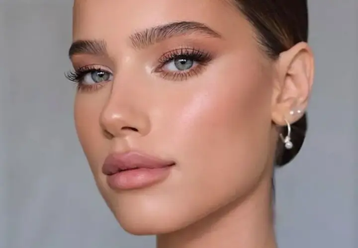 Viso di donna con trucco cerimonia impeccabile: occhi luminosi, labbra nude e pelle radiosa. Perfetto per un evento speciale.