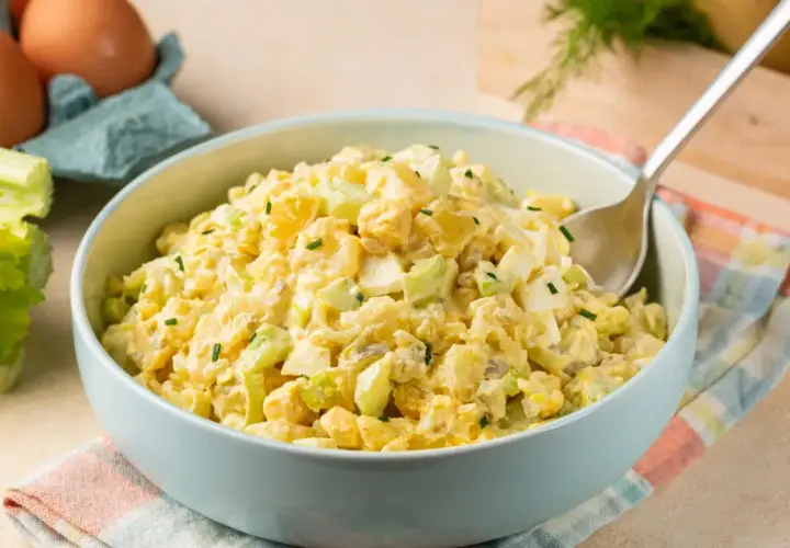 Deliciosa ensalada de apio y manzana, cremosa y fresca, con trozos de huevo duro y patata.