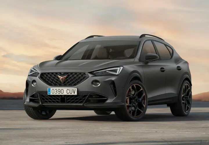 Stylowe, ciemnoszare auto Cupra z miedzianymi akcentami na felgach, zaparkowane na pustkowiu o zachodzie słońca.