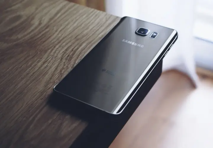 Czarny Samsung leży na drewnianym blacie. Chcesz wiedzieć, jak zresetować Samsung?