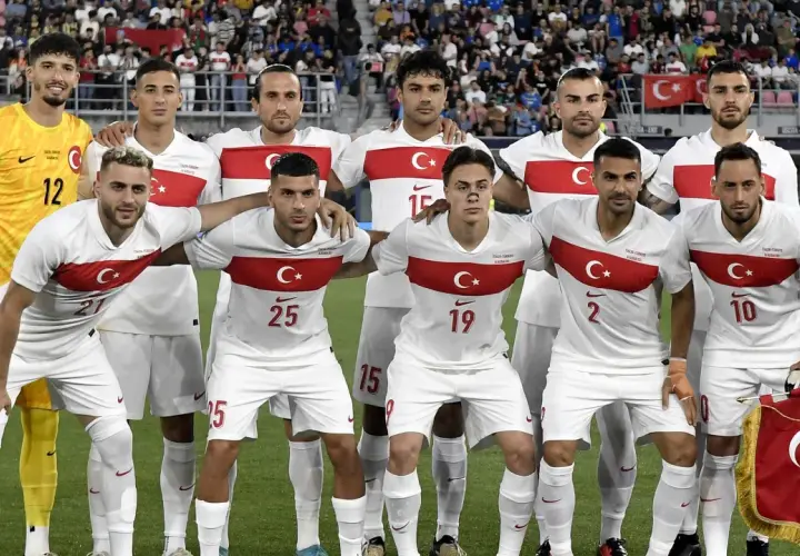 Piłkarze reprezentacji **turcja fc** w białych strojach z czerwonym pasem i godłem. Bramkarz w żółtym.