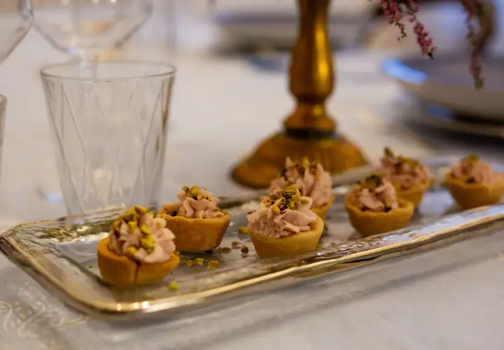 Tartellette rosa con pistacchi, pronte per un aperitivo a Verona.