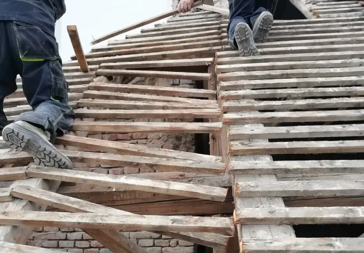 Pracownicy na dachu, wymiana krokwi. Czy wymiana krokwi wymaga pozwolenia na budowę?