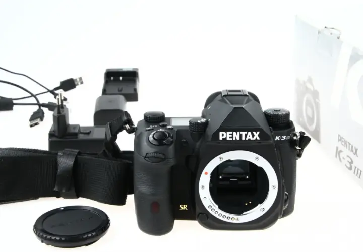 Czarny aparat Pentax K-3 III, ładowarka i akcesoria. Czy to lustrzanka czy bezlusterkowiec?