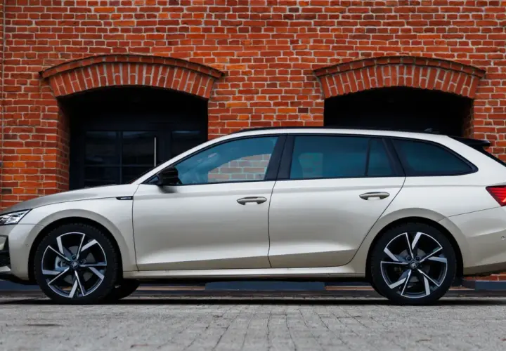 Złoty kombi Octavia 4 stoi na tle ceglanej ściany z dwoma łukowatymi oknami.