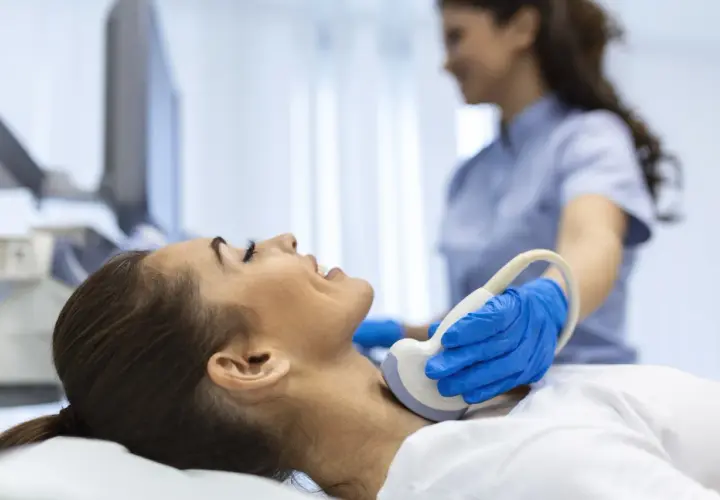 Badanie USG szyi, kluczowe dla diagnostyki tarczycy. Lekarz wykonuje badanie, by ocenić stan tarczycy, a jod jest ważnym pierwiastkiem dla jej prawidłowego funkcjonowania.