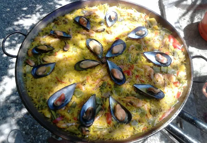 Una deliciosa fideuà mixta, con fideos dorados, mejillones jugosos y gambas, lista para compartir.