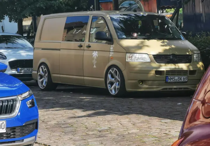Złoty bus, przeróbka busa na kampera przepisy. Stylowe felgi i naklejki dodają mu charakteru.