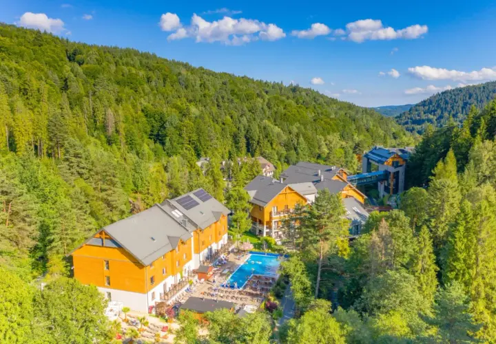 Idealne miejsce, gdzie na majówkę w Polsce: hotel w otoczeniu zielonych lasów, z basenem i miejscami do wypoczynku.