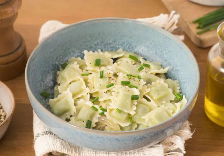 Un plat de ravioli du Dauphiné, généreusement garnis et saupoudrés de ciboulette fraîche et de poivre noir.