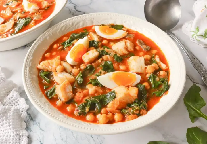 Un reconfortante potaje de vigilia con garbanzos, espinacas y trozos de pescado blanco, coronado con huevos duros.
