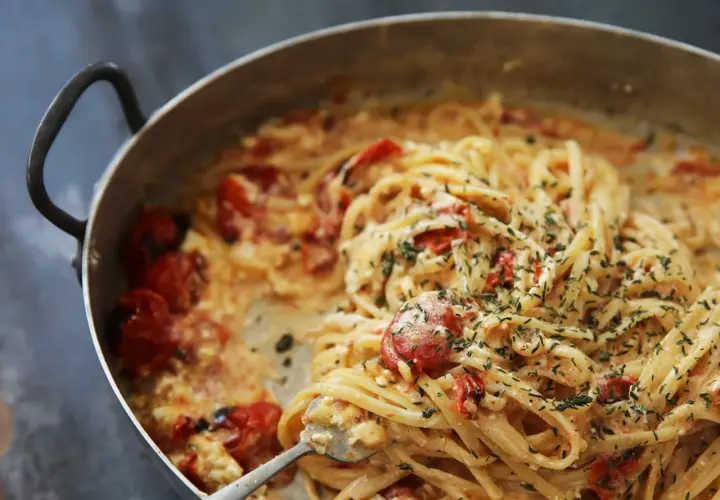 Pâtes crémeuses aux tomates cerises et herbes fraîches, servies dans une poêle. Un délice !