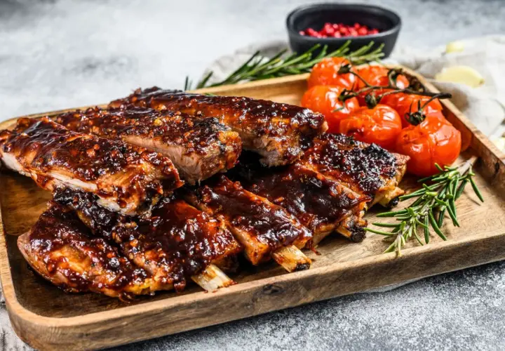 Soczyste żeberka w sosie barbecue, podane z pieczonymi pomidorkami i rozmarynem. Idealne danie, gdy zastanawiasz się, co zrobić z ugotowanych żeberek.
