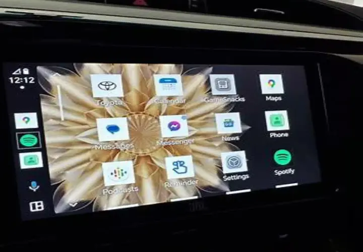 Ekran samochodu z aplikacją Android Auto. Widoczne ikony: Toyota, Kalendarz, Gry, Mapy, Wiadomości, Telefon, Spotify, Ustawienia, Podcasty, Przypomnienia, Messenger.