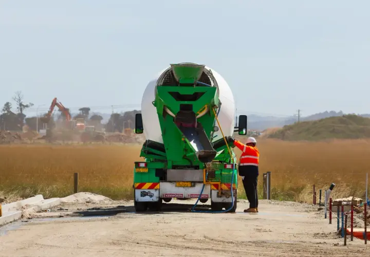 Robotnik przy betoniarce, przygotowuje się do pracy. Cena betonu zależy od wielu czynników.