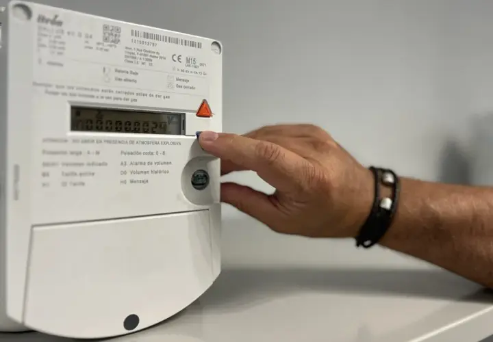 Mano interactuando con un contador digital de gas.