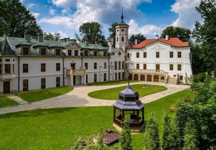 Pałac w Nawojowej z wieżą i altaną na dziedzińcu.