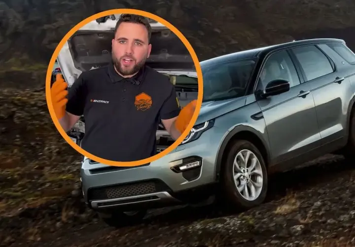 Opiniones sobre el motor Land Rover 3.0 TDV6. Mecánico con guantes naranjas habla junto a un Land Rover Discovery en terreno accidentado.