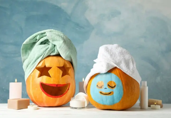 Dwie dynie po zabiegu SPA. Jedna z wyciętymi gwiazdami i czerwoną buzią, druga z niebieską maseczką i zamkniętymi oczami. Ta praca plastyczna dynia to relaks!