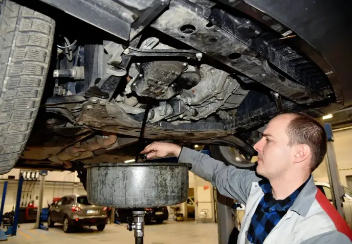 Mechanik spuszcza stary olej z silnika. Zastanawiasz się, ile trwa wymiana oleju? Zazwyczaj to szybka czynność.