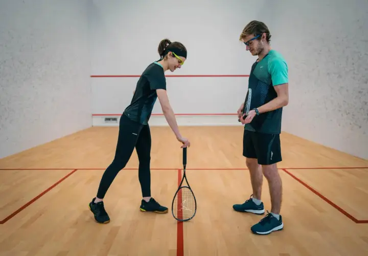 Para, która omawia zasady squash serwisu na korcie.