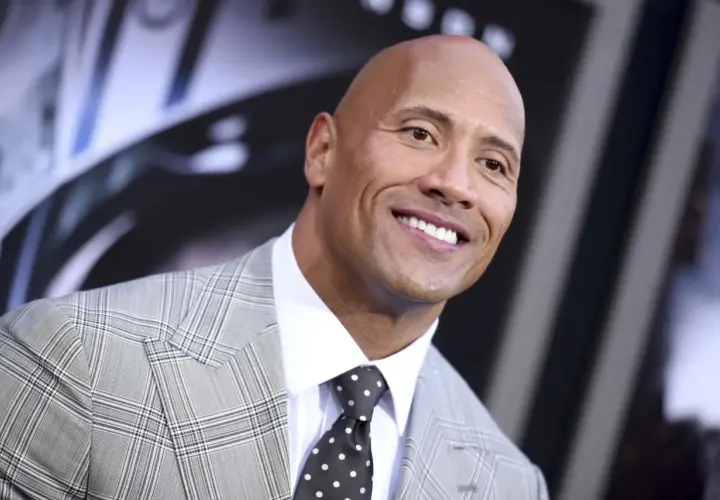 Uśmiechnięty Dwayne "The Rock" Johnson w garniturze. Ciekawe, ile lat ma The Rock, gdy patrzy tak promiennie?
