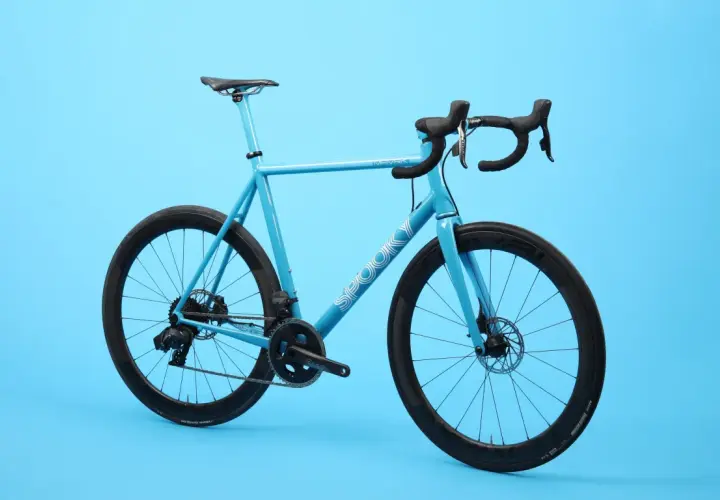 A bright blue road bike with black wheels and handlebars. The word "SPOOKY" is visible on the frame, hinting at these spooky bikes.