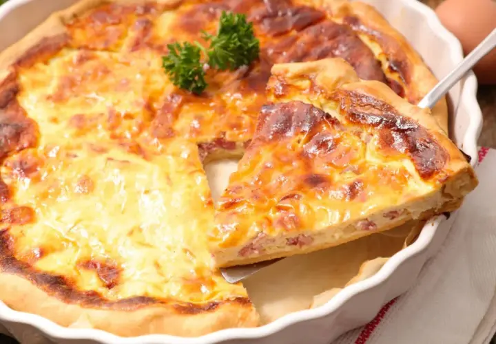 Une part de quiche lorraine dorée et appétissante, prête à être dégustée. La vraie recette quiche lorraine, un délice !