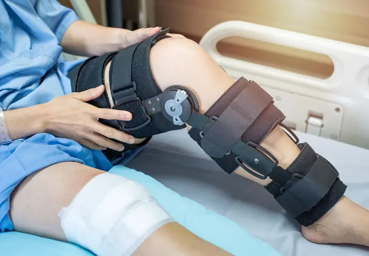Patient mit Knieorthese, die von der Krankenkasse bezahlt wird, liegt im Krankenhausbett.