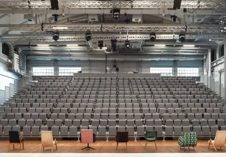 Widownia i scena Teatru Nowego w Warszawie. Puste, szare fotele czekają na widzów.