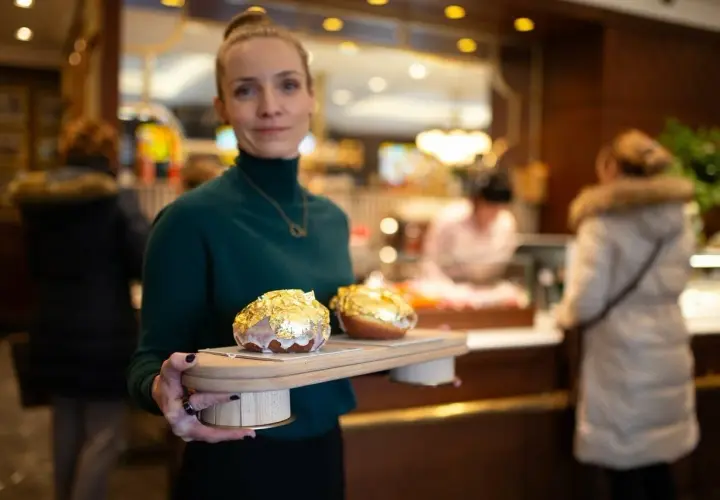 Elegancka piekarnia po francusku prezentuje dwa pączki w płatkach złota.