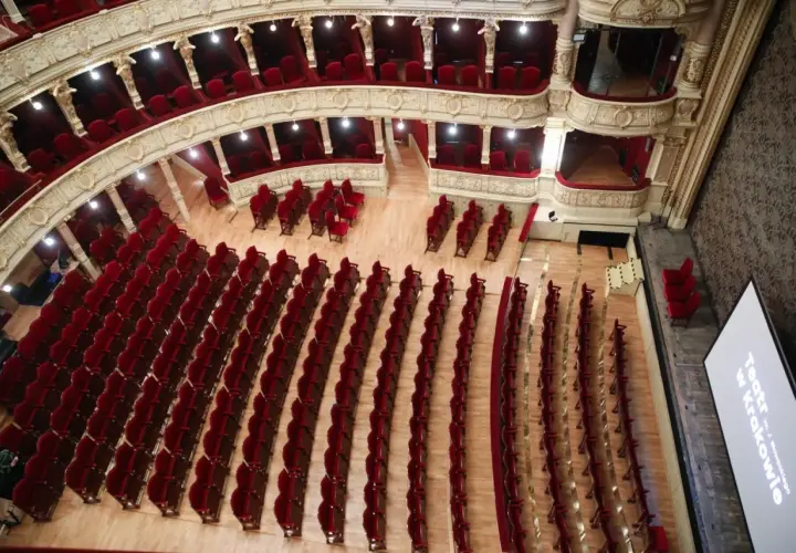 Widok z góry na bogato zdobione wnętrze Teatru im. Juliusza Słowackiego w Krakowie. Puste, czerwone fotele czekają na widzów, gotowe na kolejne spektakle.
