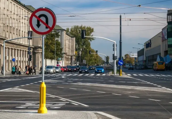 Znak zakazu skrętu w lewo na skrzyżowaniu z ruchem ulicznym i pieszymi.