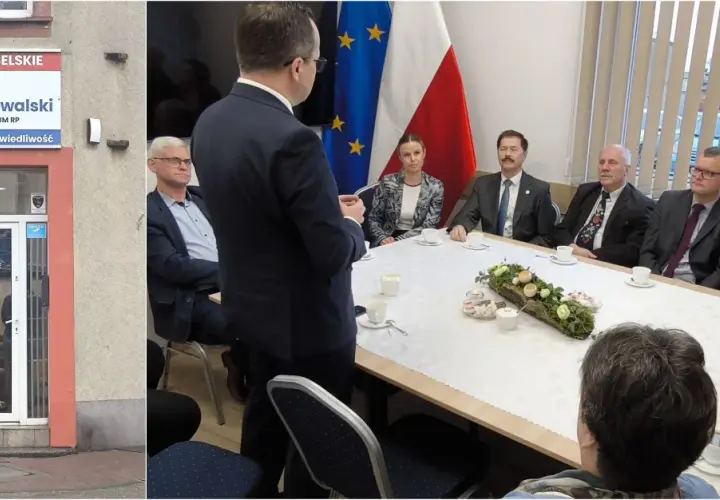 Biuro poselskie Michała Kowalskiego. Spotkanie przy stole z flagami Polski i UE.