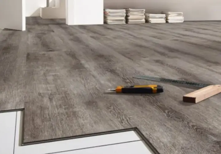 Installazione pavimenti LVT: un taglierino e una squadra pronti per correggere eventuali difetti.