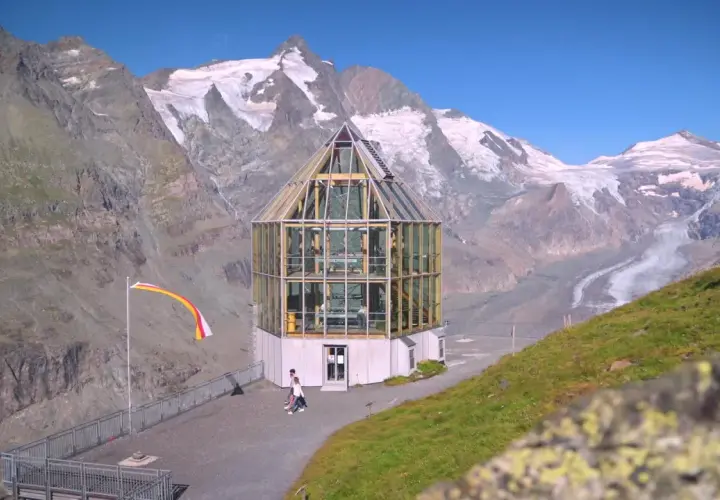 Szklana budowla na tle najwyższego szczytu Austrii, Grossglockner. Lodowiec w oddali.