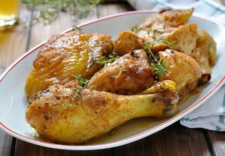 Sovracosce di pollo al forno dorate e succulente, guarnite con rametti di timo fresco. Un piatto invitante pronto per essere gustato.