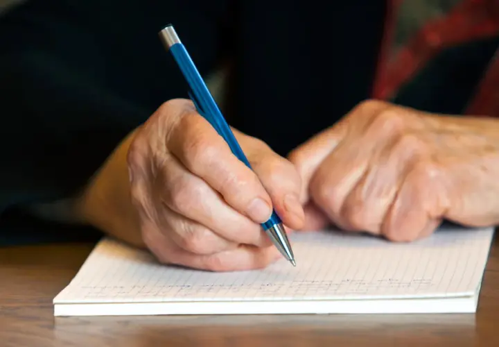 Manos de abuela escribiendo una carta a mi nieto en su cumpleaños.