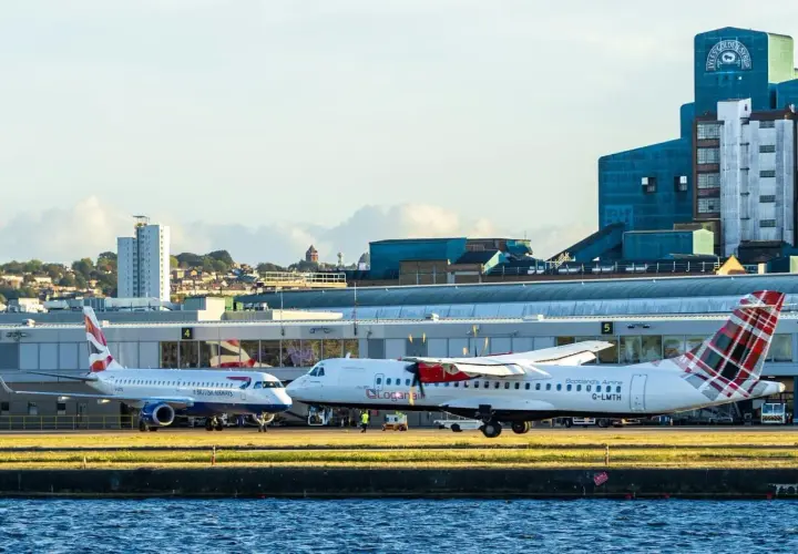 British Airways und Loganair Flugzeuge am London Flughafen. Im Hintergrund die markante Lyle's Golden Syrup Fabrik.