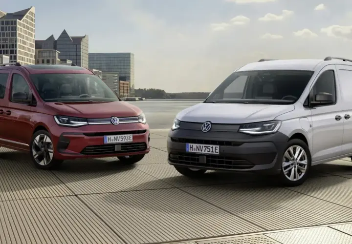 Dwa Volkswageny Caddy 3: czerwony osobowy i biały dostawczy, stoją na tle nowoczesnej architektury i wody.