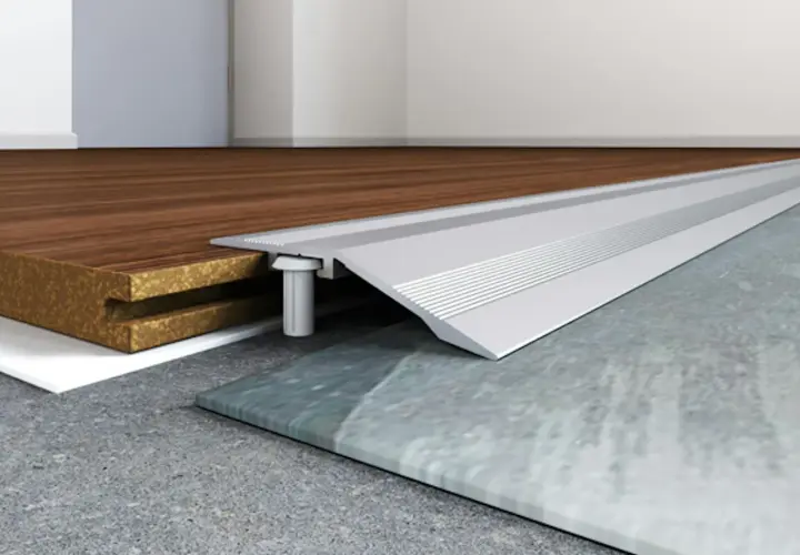 Profilo metallico per accostare pavimenti diversi, come legno e pietra, garantendo una transizione fluida e sicura.