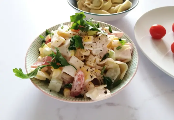 Pyszna sałatka z tortellini, jajka, kukurydzy i warzyw, polana kremowym sosem. To najlepsza sałatka z tortellini na lato!