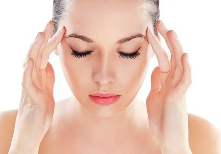 Donna con le mani sulle tempie, soffre di mal di testa da stress. Scopri come farlo passare con rimedi naturali.