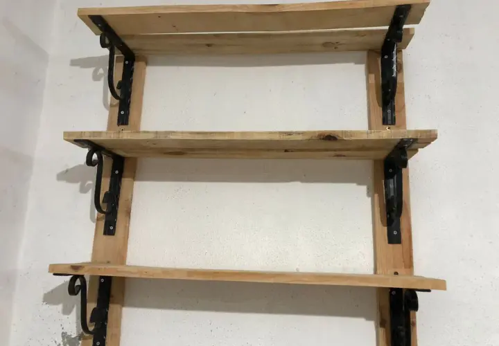 Scaffali in legno fai da te, con staffe nere decorative, perfetti per un tocco rustico.