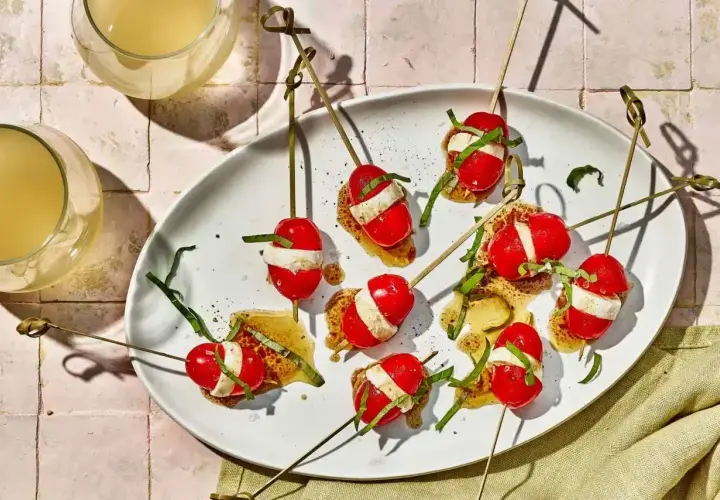 Proste przepisy na przekąski w 15 minut: szaszłyki caprese z pomidorków, mozzarelli i bazylii na chrupiącym grzanie.