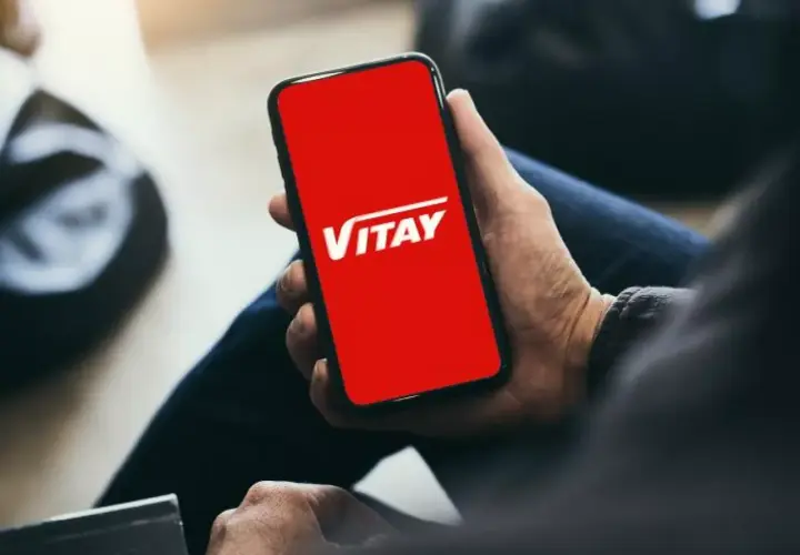 Dłoń trzyma smartfon z czerwoną kartą VITAY.