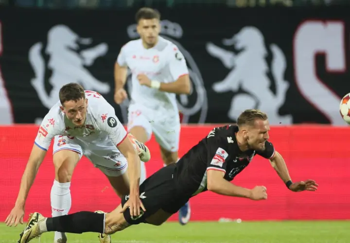 Piłkarz w czarnym stroju upada, próbując ratować piłkę. Czy można dobijać rzut karny w takiej sytuacji?