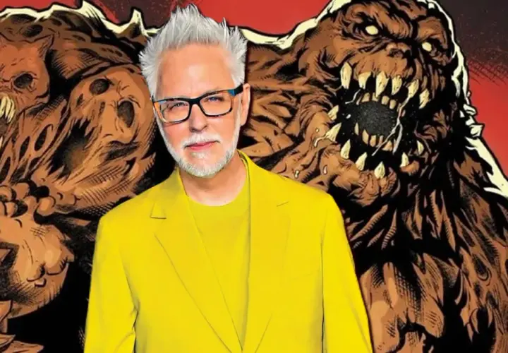 James Gunn, en costume jaune vif, pose devant des créatures monstrueuses en terre, évoquant un futur film Swamp Thing.